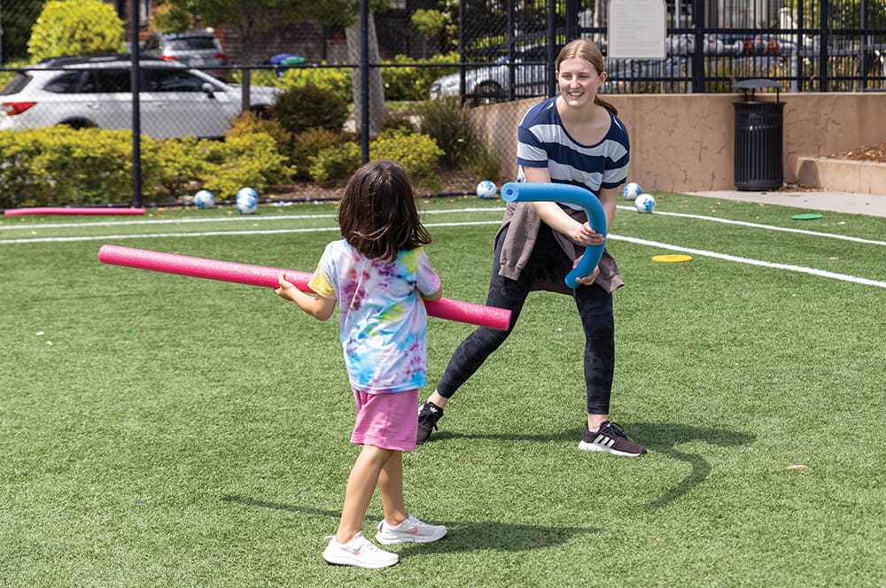 Teenager playing a game with a little girl.