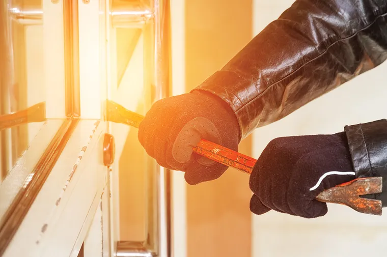 Someone breaking into a door with a crowbar